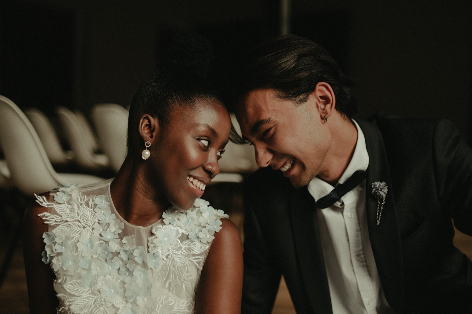interacial bride and groom look at each other smile and lock eyes
