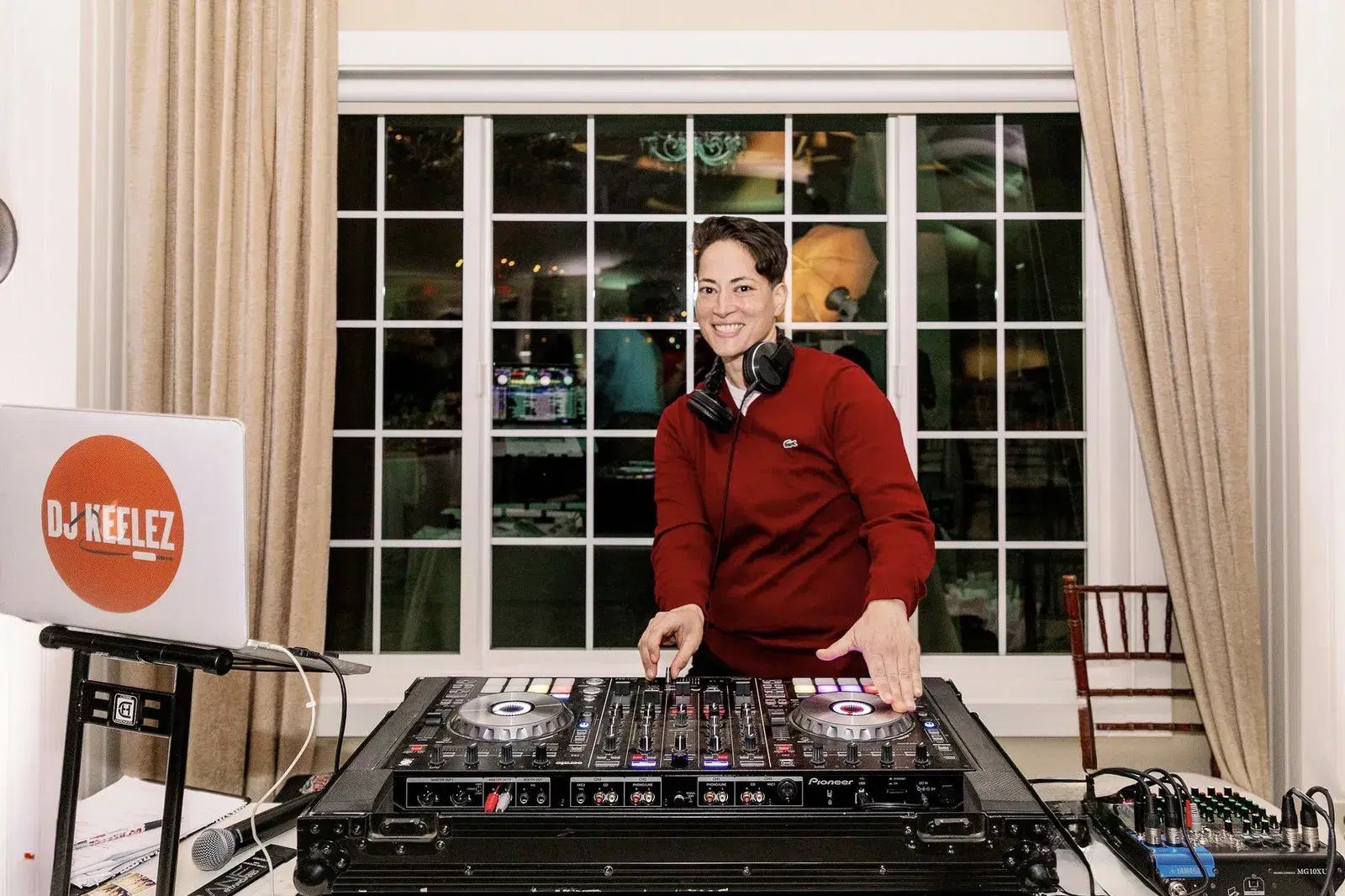 DJ Keelez smiling behind her DJ controller while performing at a Los Angeles private event