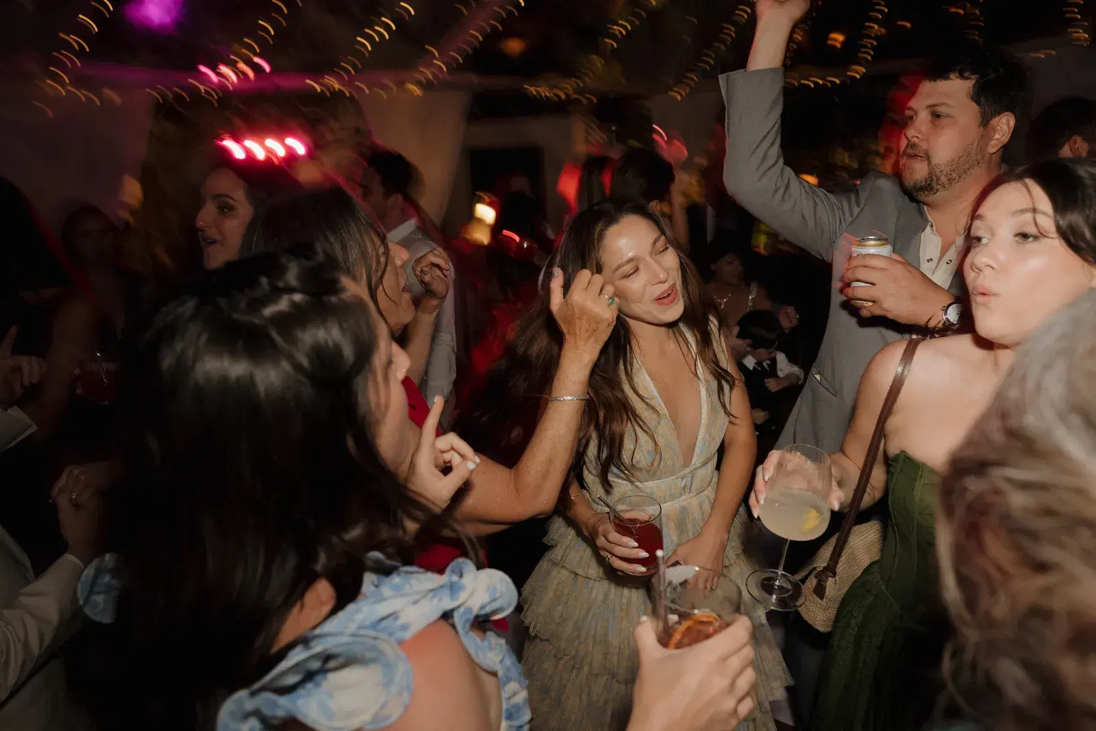 Guests dancing and singing along on a crowded wedding reception dance floor
