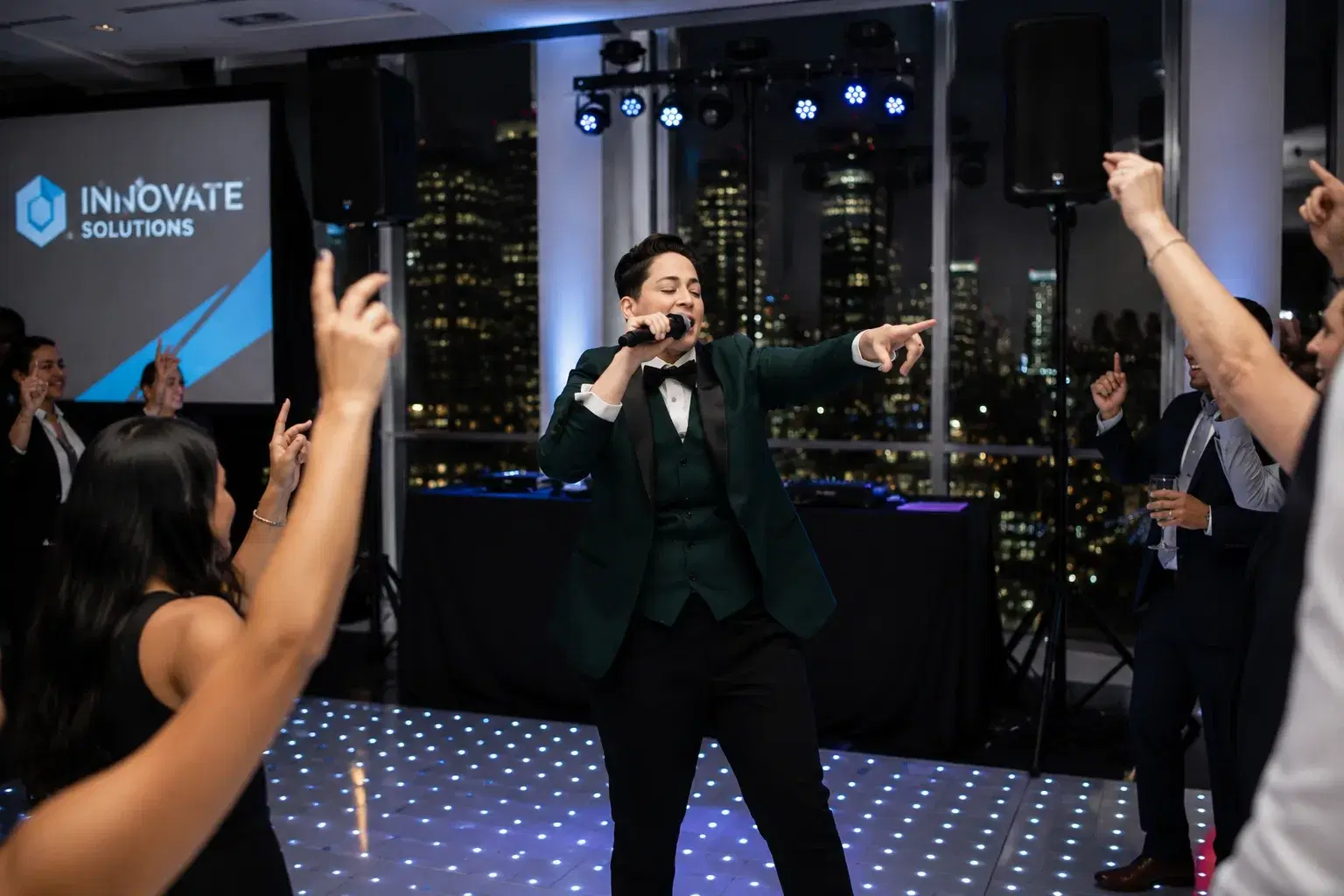 DJ Keelez emceeing on the mic from a light-up dance floor at a branded corporate event in Los Angeles