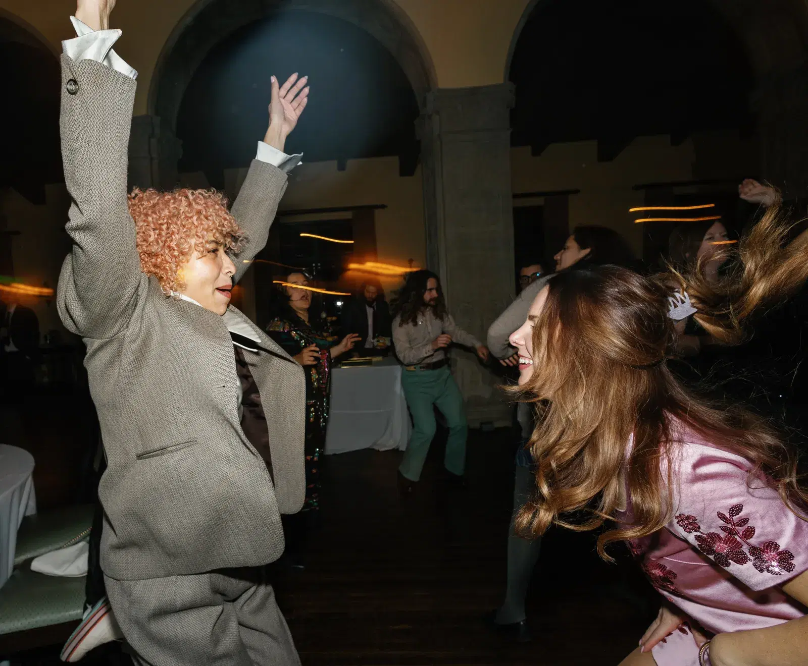 Guests dancing with arms raised at an LA company holiday party