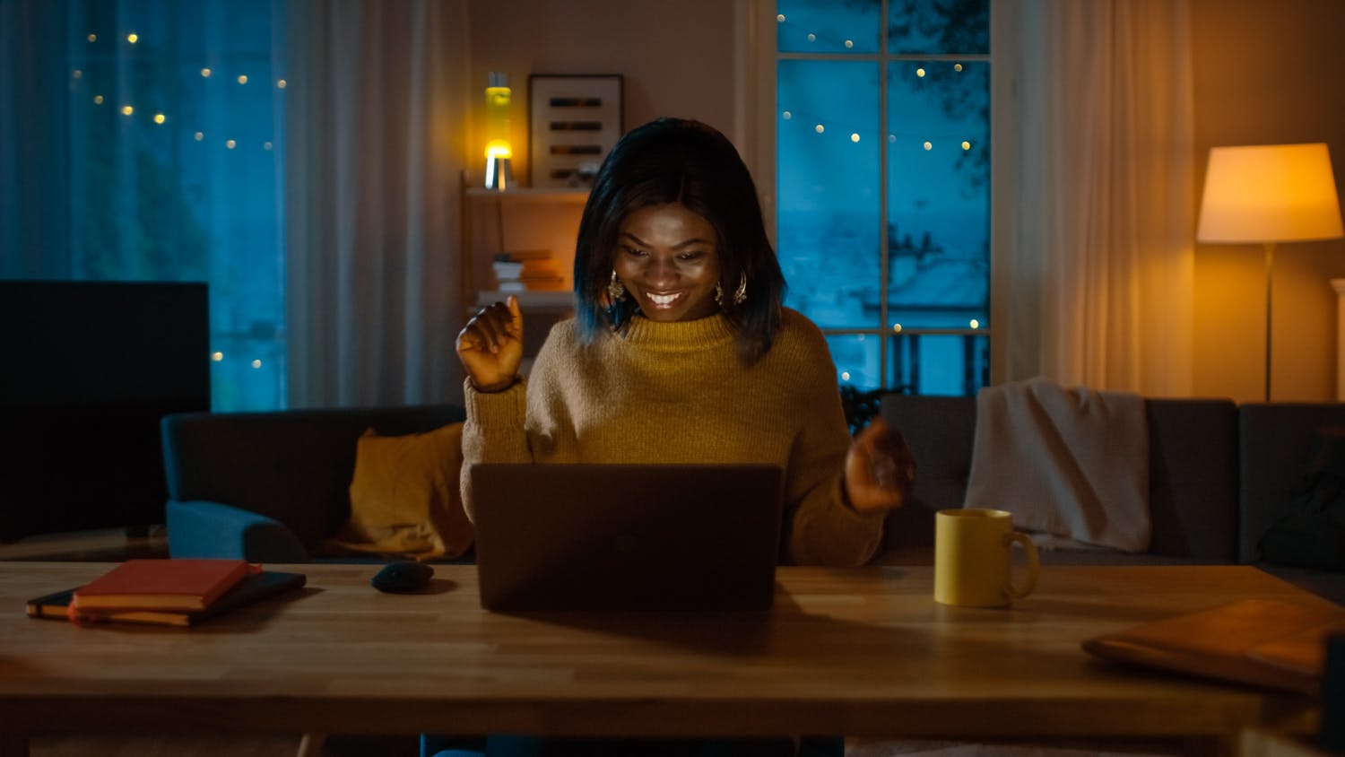 Black woman in front of laptop smiling in virtual event