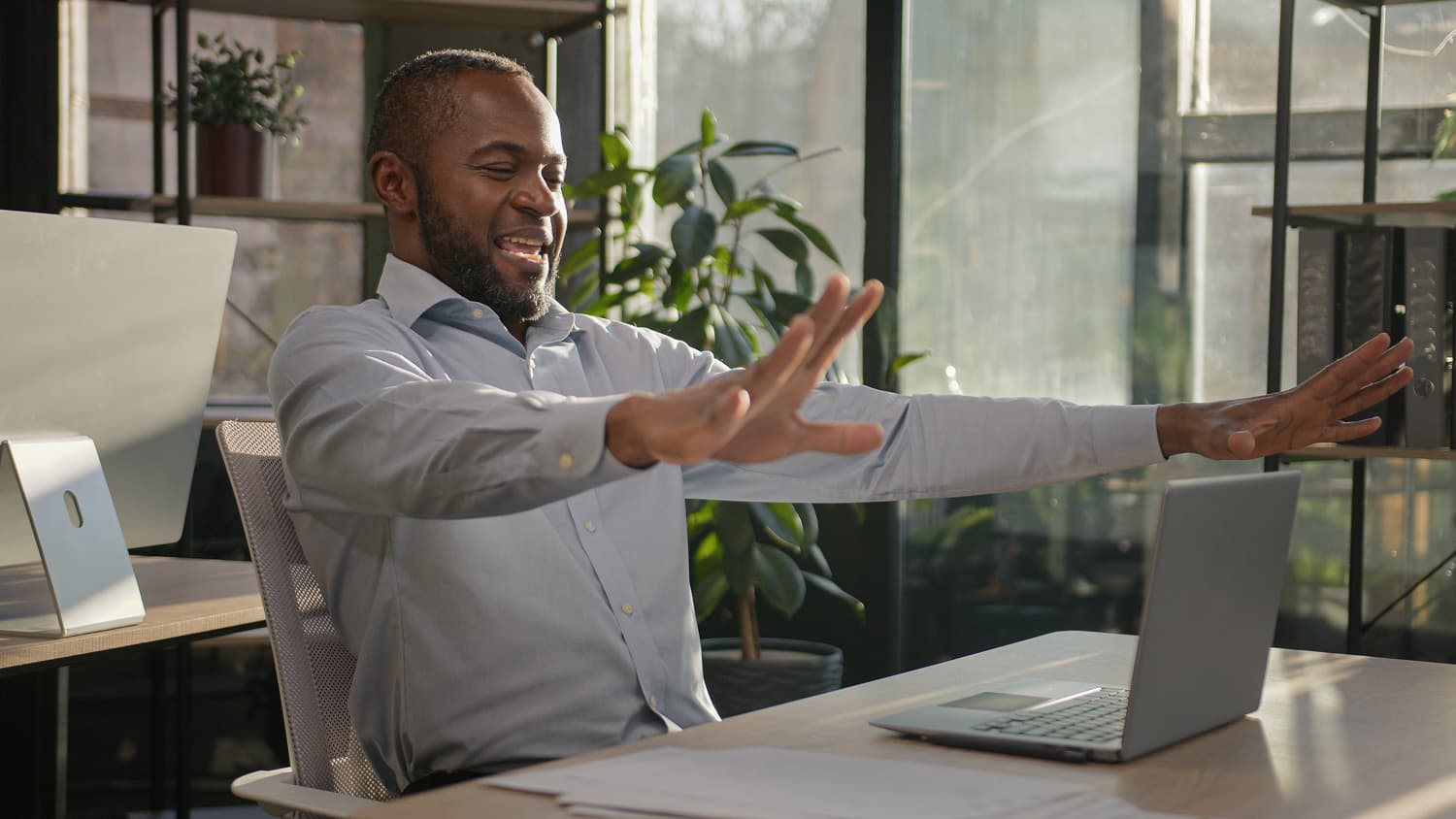 Black man smiling and enjoying his self in front of a laptop